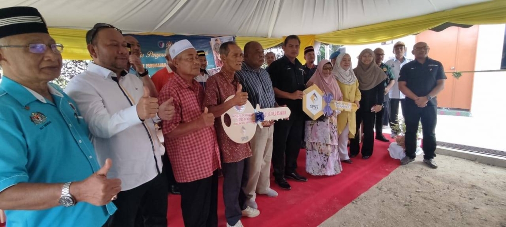 Zambery Jeffery (enam kanan) bergambar bersama empat penerima replika kunci rumah di bawah Program Inisiatif Perumahan Veteran ATM di Kampung Chantek Bangun, Mukim Sanglang, Kangar pada Khamis.