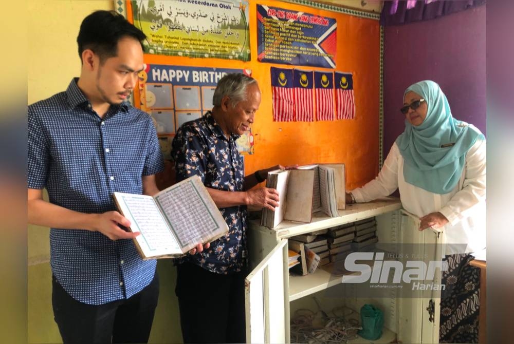 Muhammad Nasir (tengah) dan Izzat Ilyas (kiri) melihat al-Quran rosak yang ditunjukkan oleh Nurmizan.