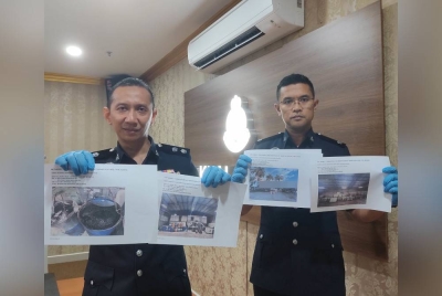 Ahmad Ridhwan (kiri) menunjukkan gambar rampasan membabitkan kegiatan pemindahan diesel bersubsidi di sebuah gudang di Kampung Sungai Jarom, Kuala Langat pada Isnin.