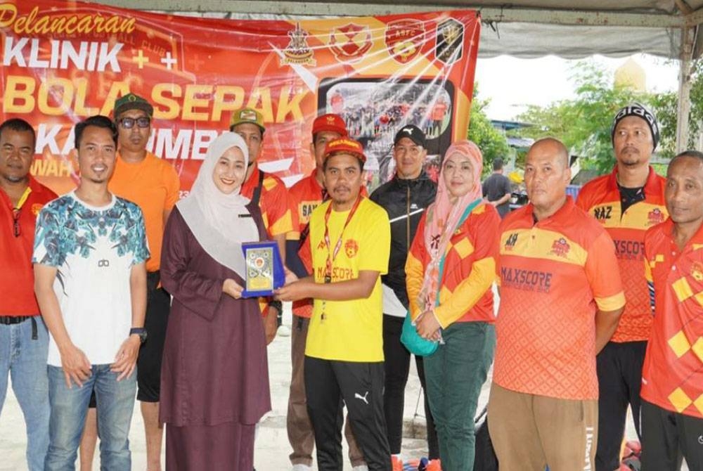 Faizal menyerahkan cenderahati kepada Penyelaras DUN Sementa, Afrieshah Azizi selepas klinik bola sepak berkenaan.