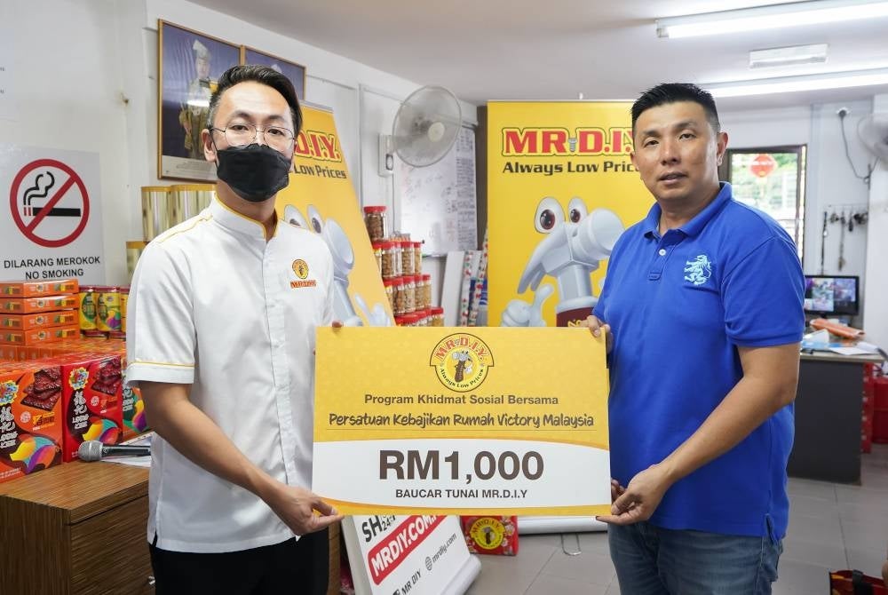 Alex Goh, Ketua Pemasaran Kumpulan MR D.I.Y. (Kiri) menyerahkan sumbangan MR D.I.Y kepada (Kanan) Loo Choon Teong dari Persatuan Kebajikan Rumah Victory.