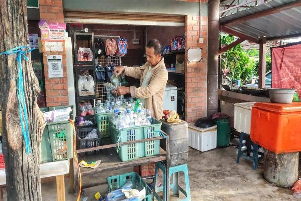 Abdul Rahman mengenakan baju sejuk ketika menguruskan kedai runcitnya di Kampung Lubuk Tualang di sini pada Sabtu.