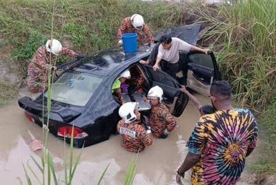 Pasukan bomba mengeluarkan wanita sebelum disahkan maut oleh pasukan perubatan dalam kejadian di Jalan Chui Chak - Langkap, Teluk Intan pada Sabtu. -Foto: Ihsan JBPM Perak