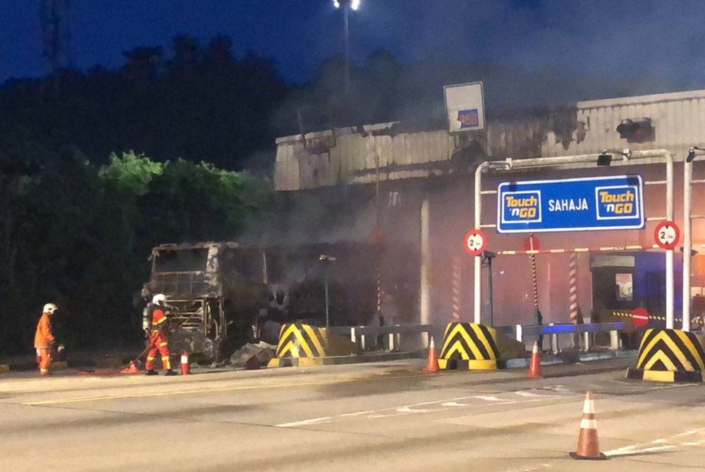 Anggota bomba sedang melakukan usaha memadam kebakaran membabitkan sebuah bas persiaran di Plaza Tol UPM pada pagi Ahad.