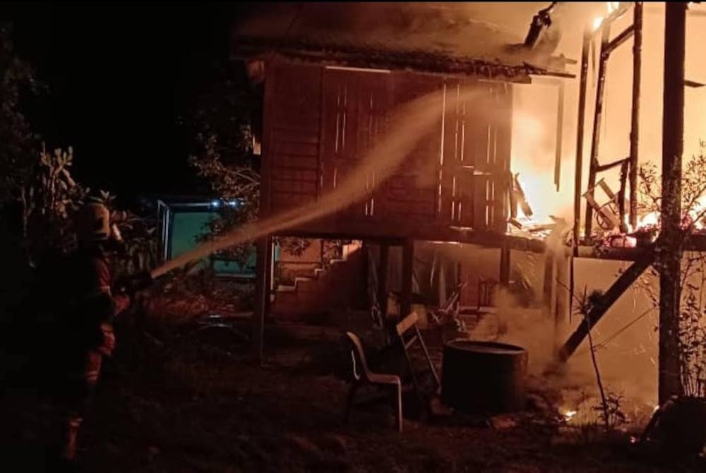 Anggota bomba sedang memadamkan kebakaran. - Foto JBPM Perak