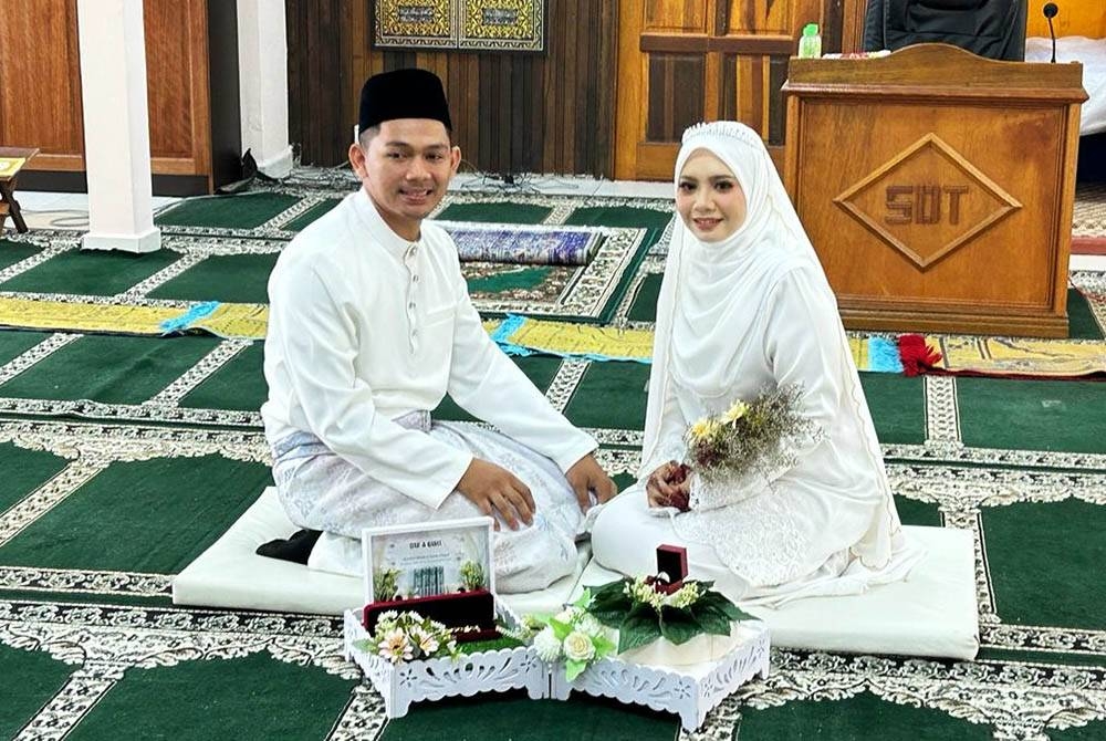 Pasangan pengantin Nurul Nadia dan suami, Muhammad Khairul Nizam ketika upacara akad nikah di Surau Darul Taqwa, Perumahan Kuala Telemong, di Kuala Terengganu. - Foto Ihsan keluarga i