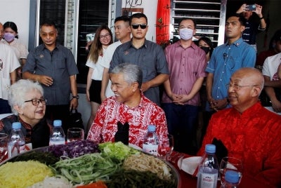 Ahmad Zahid (duduk, tengah) menyantuni Cheah Seoh Lian, 85, (duduk, kiri) ibu kepada rakan karibnya Beh Song Wan, 60, (duduk, kanan) ketika menziarahi mereka sempena sambutan Tahun Baharu Cina di Taman Desa Bersatu, Bagan Datuk pada Isnin. - Foto Bernama
