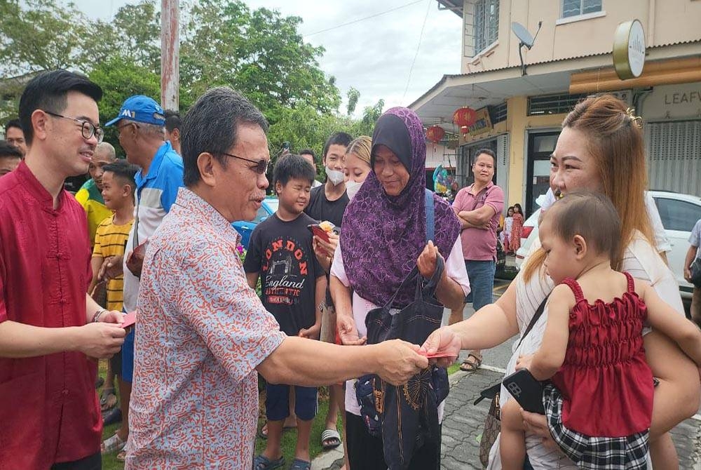 Mohd Shafie ketika menyampaikan angpau ketika hadir pada majlis Rumah Terbuka Sambutan Tahun Baharu Cina ADUN Tanjung Aru Datuk Junz Wong, di Pejabat ADUN Tanjung Aru, Kota Kinabalu.
