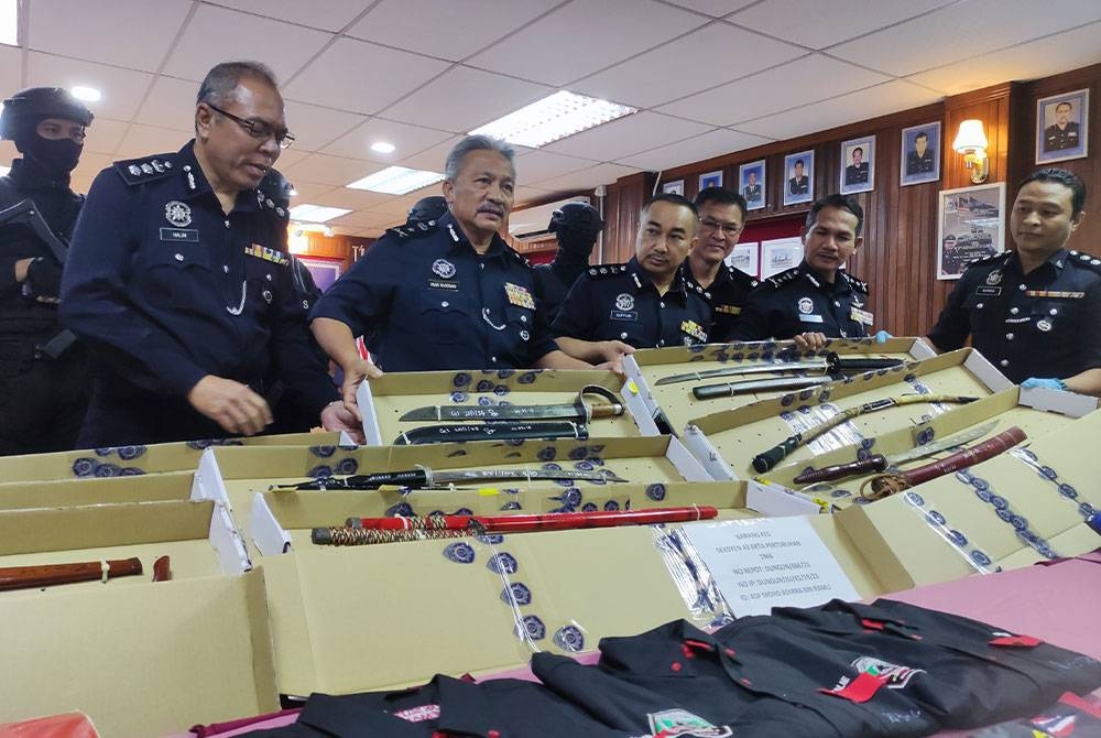 Rohaimi (dua dari kanan) menunjukkan senjata yang dirampas daripada kumpulan Ayahanda Harimau Kumbang.