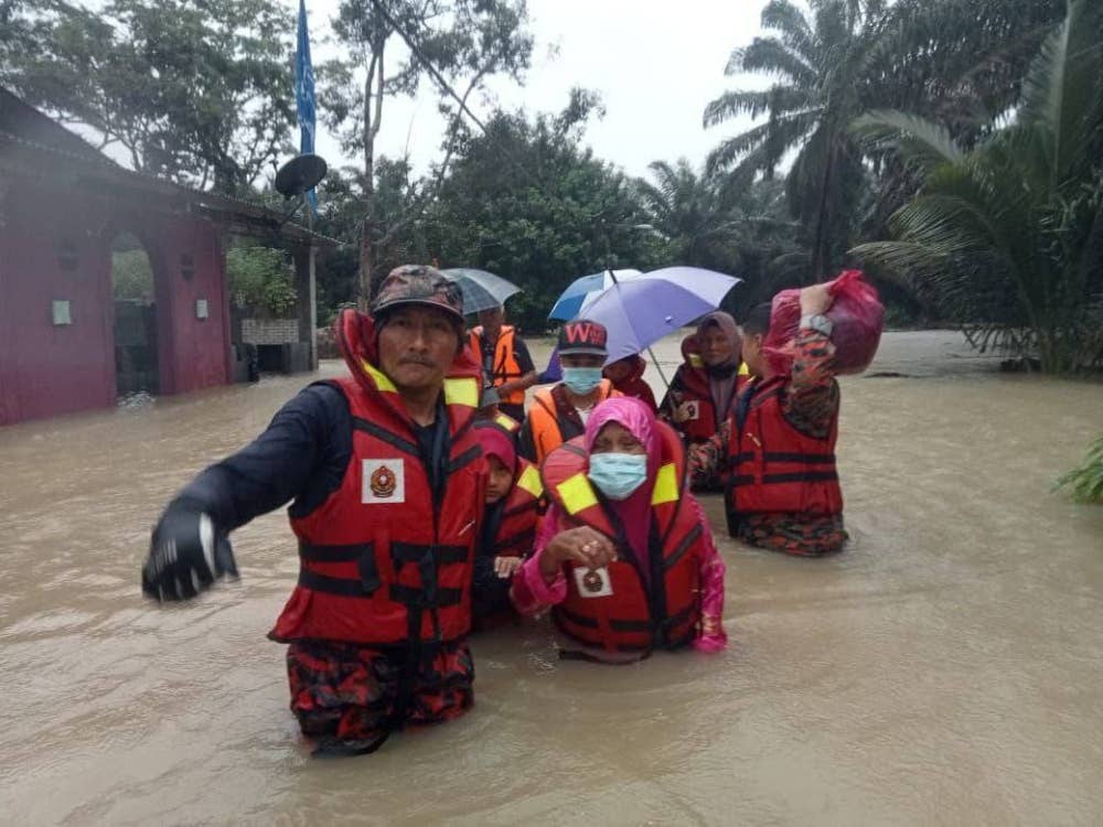 Anggota bomba memindahkan mangsa banjir di Kampung Paya Merah ke PPS di Dewan Serbaguna Kampung Paya Merah, Labis, Segamat, pada Selasa