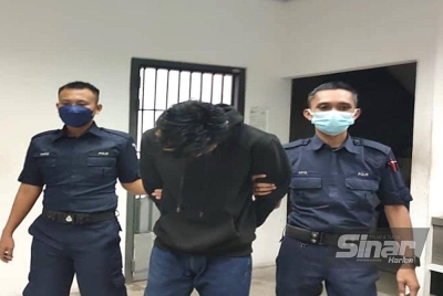 Hafiy Zulhilmy (tengah) dibawa polis menuju ke lokap Mahkamah Kota Bharu. FOTO SINAR HARIAN