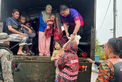 Anggota bomba memindahkan mangsa banjir dari Taman Desaru Utama ke PPS SK Bandar Penawar, Kota Tinggi, pada Selasa. - Foto ihsan bomba Johor