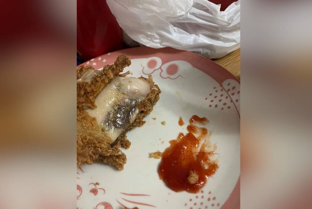 Seorang pelanggan mendakwa ayam yang dibeli di sebuah restoran makanan segera di Kemaman tidak dimasak dengan sempurna dan berbau. - Foto Facebook