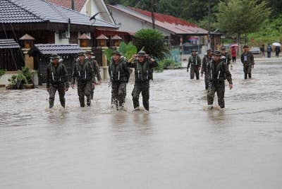 Anggota tentera meredah sekitar taman bagi membantu menyelamatkan mangsa-mangsa banjir di Kota Tinggi, Johor. - Foto Bernama.