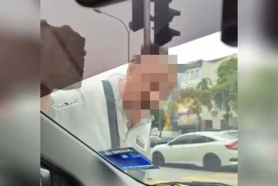 Video tular yang memaparkan seorang lelaki warga emas mengetuk cermin kereta dengan batu.