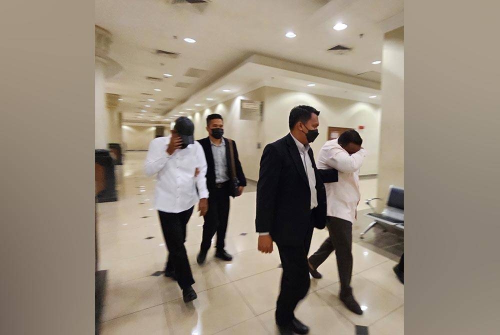 Kedua-dua tertuduh diiringi pegawai SPRM keluar dari mahkamah selepas selesai sebutan kes mereka dalam Mahkamah Sesyen Kuantan pada Khamis