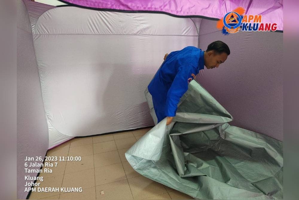 Anggota APM mengemas semula khemah sementara berikutan penutupan salah sebuah PPS di Kluang, pada Khamis. - Foto APM Kluang