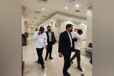 Kedua-dua tertuduh diiringi pegawai SPRM keluar dari mahkamah selepas selesai sebutan kes mereka dalam Mahkamah Sesyen Kuantan pada Khamis