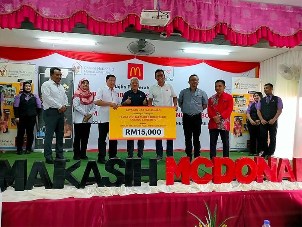 Azmir (lima dari kanan) menyampaikan replika cek dana biaya RM15,000 daripada Yayasan Jaafar Ahmad.