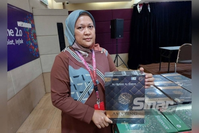 Roziyana menunjukkan satu tajuk al-Quran yang diberi diskaun sebanyak 50 peratus pada Jumaat.