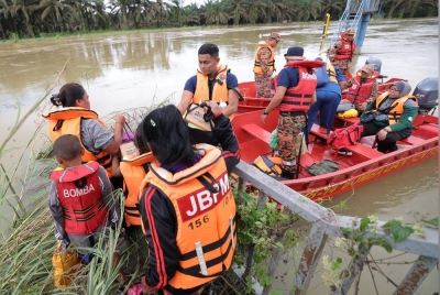 Anggota Jabatan Bomba dan Penyelamat Malaysia (JBPM) daerah Kluang membantu menghantar petugas kesihatan dan penduduk setempat ke Kampung Orang Asli Pucur, Kahang selepas laluan darat di kawasan itu ditenggelami air ketika tinjauan di Jeti Kahang, pada Jumaat. - Foto Bernama