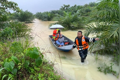 Anggota penyelamat membantu memindahkan mangsa banjir. 