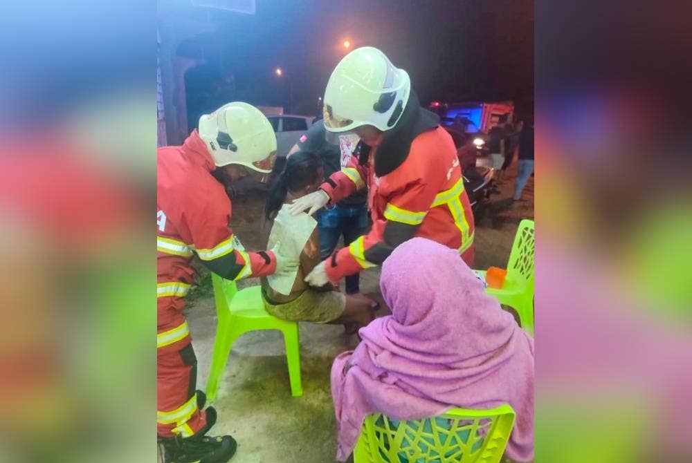 Mohd Azlan (tengah) yang melecur dibantu oleh anggota bomba sebelum dibawa ke hospital untuk mendapatkan rawatan lanjut.