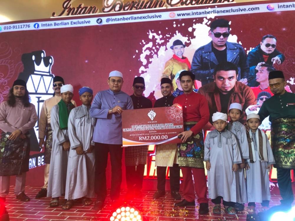 Penyelia Rumah Anak Yatim Pertubuhan Kebajikan Insan Kelantan, Hafizuddin Hamzah (tengah) menerima sumbangan tunai RM2,000. 