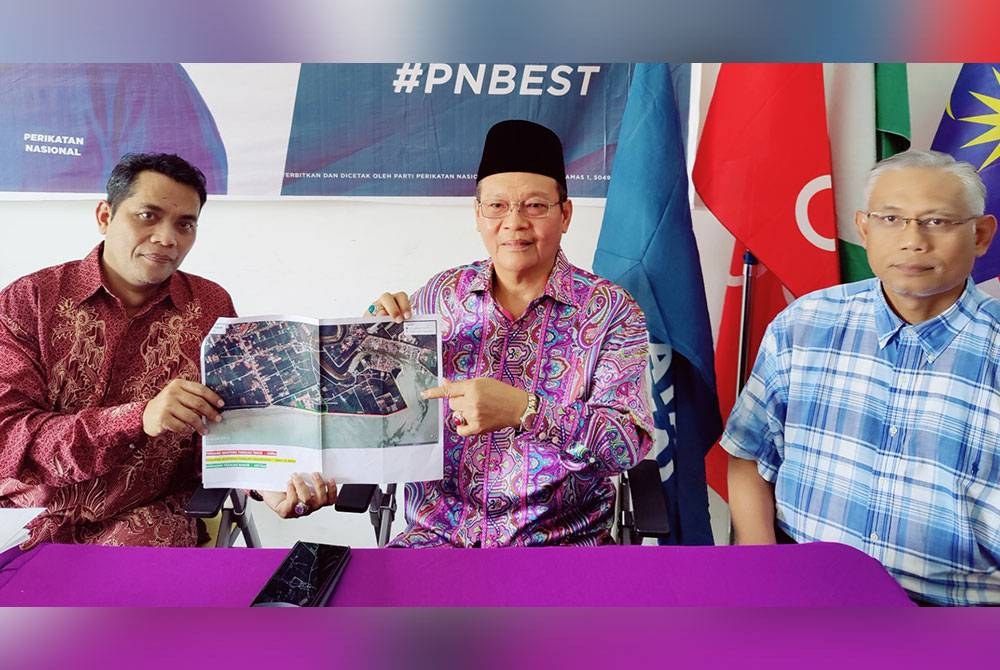 Zulkafperi (tengah) menunjukkan peta Pantai Sungai Kajang pada sidang akhbar di Pejabat Ahli Parlimen Tanjong Karang di sini pada Ahad.