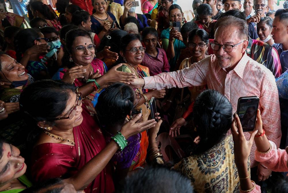 Anwar bersalaman bersama tetamu ketika hadir pada Program Sambutan Hari Ponggal 2023 Peringkat Parlimen Tambun di Sekolah Jenis Kebangsaan Tamil Klebang hari ini. - Foto Bernama