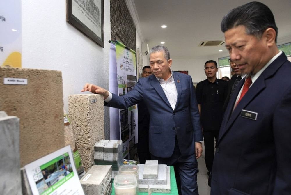 Fadillah (kiri) melihat produk keluaran LKTN di Kubang Kerian, Kota Bharu.