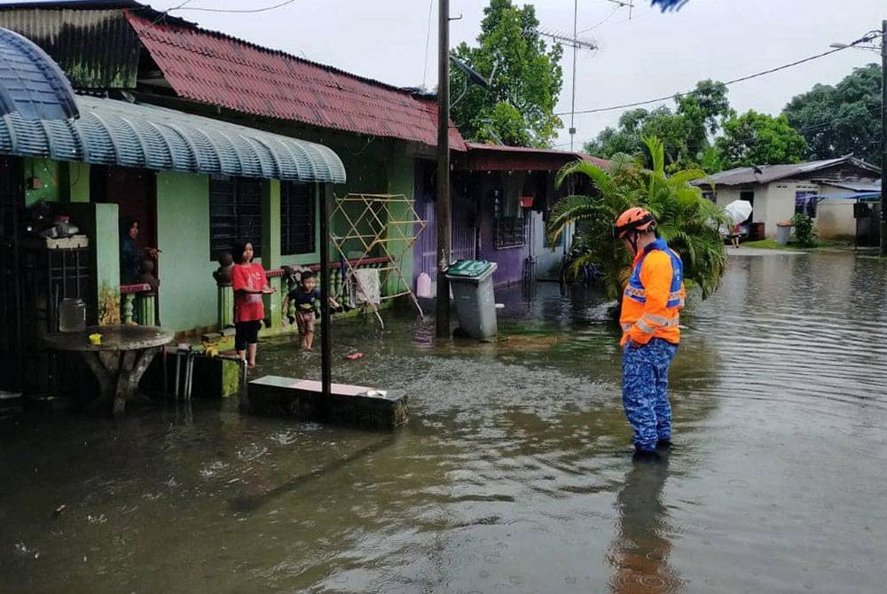 Anggota Angkatan Pertahanan Awam Malaysia (APM) memantau keadaan banjir di Jalan Bedara, Batu Pahat, Johor. - Foto ihsan APM Batu Pahat