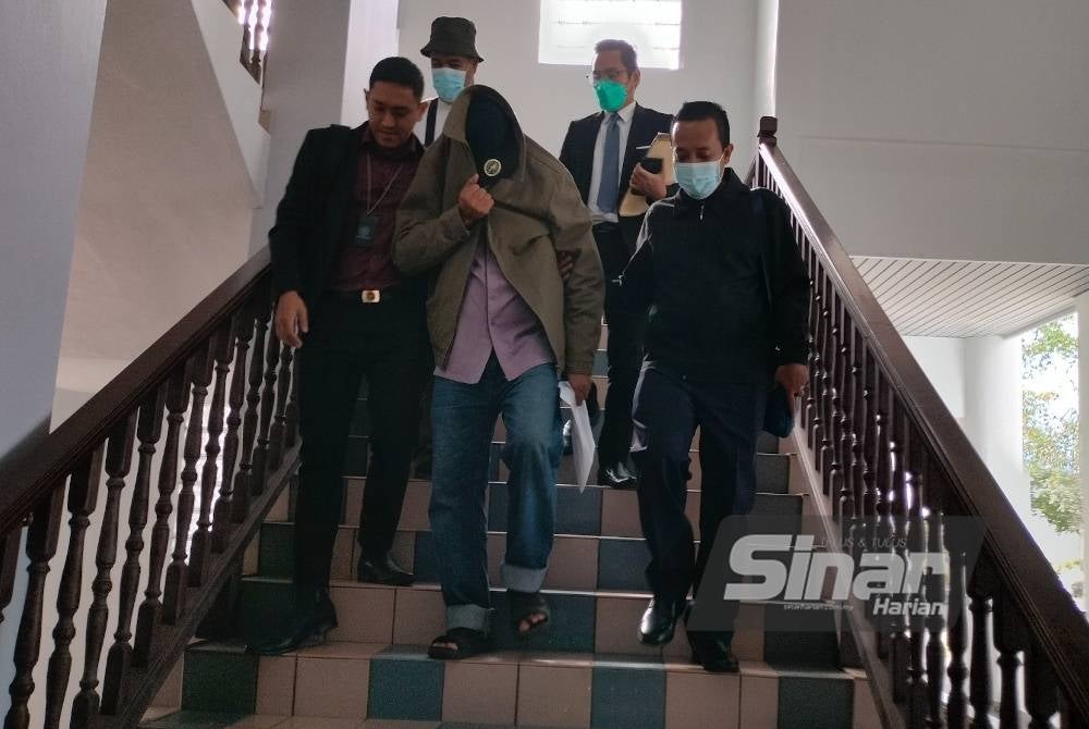 Mohd Azmi (dua dari kiri) didakwa di Mahkamah Sesyen Melaka pada Selasa.