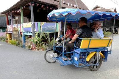 Hanya dengan bayaran RM35, pengunjung dapat menikmati keunikan persekitaran Projek DiRaja Program Transformasi Kampung Warna-Warni Seberang Ramai, Kuala Perlis di sini dengan menaiki 'Choley' atau motosikal beroda tiga. - Foto Bernama