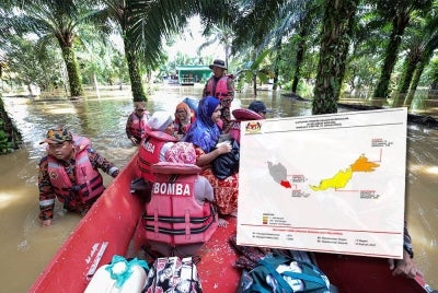 Anggota Bomba dan Penyelamat memindahkan sebahagian penduduk yang rumah mereka mula dinaiki air di Kampung Rancangan Cocos, Pamol - Foto: Bernama (Gambar kecil: Laporan yang dikeluarkan Nadma setakat jam 4 petang pada Selasa.)