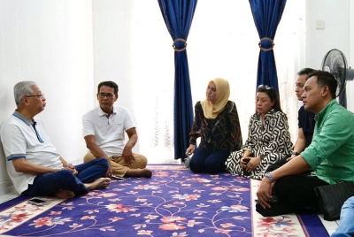 Ismail Sabri (kiri) berbual dengan Rosli (dua dari kiri) ketika berkunjung ke rumah bekas wartawan hiburan itu, pada Rabu.