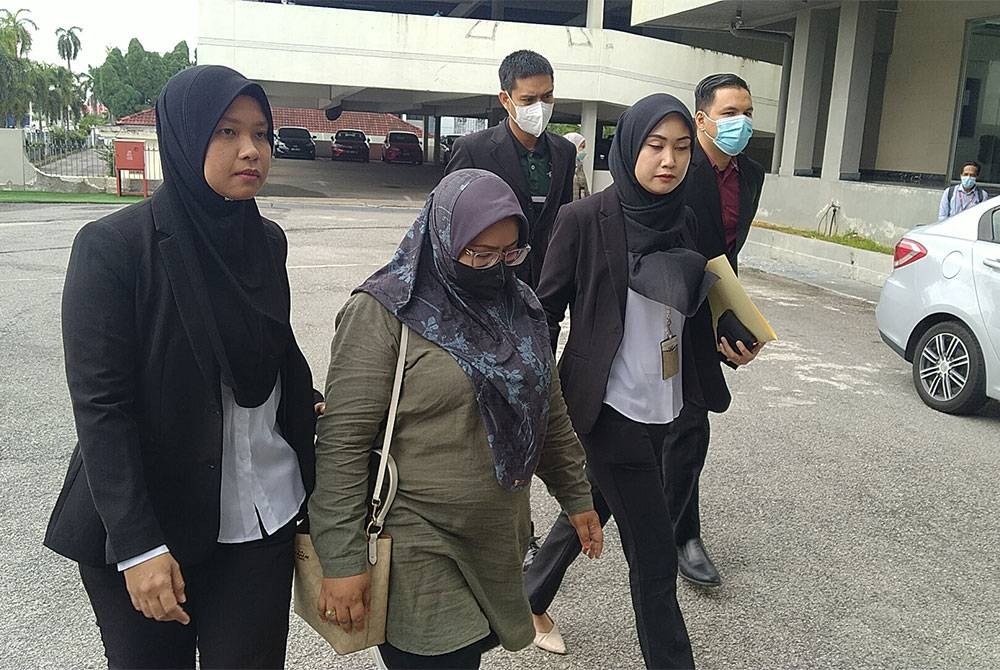 Fauziah (dua dari kiri) dihadapkan ke Mahkamah Sesyen Ipoh atas pertuduhan pecah amanah pada Khamis