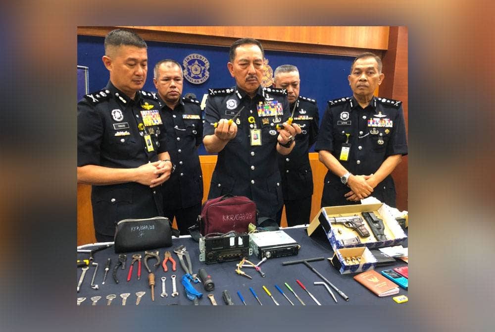 Muhamad Zaki (tengah) menunjukkan alatan berbentuk T yang tajam pada bahagian hujung digunakan untuk mengumpul kunci kenderaan