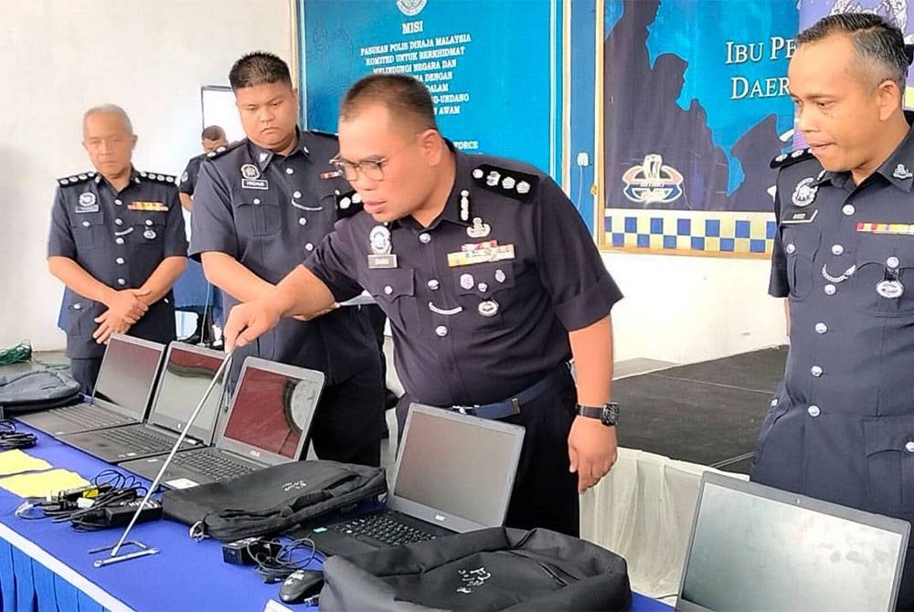 Bahrin (dua dari kanan) menunjukkan barang-barang rampas selepas menahan tiga lelaki dikenali Geng Rongak pada Selasa.