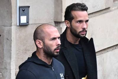 Andrew Tate (kiri) dan Tristan Tate keluar dari sebuah mahkamah di mahkamah Bucharest, Romania. - AFP