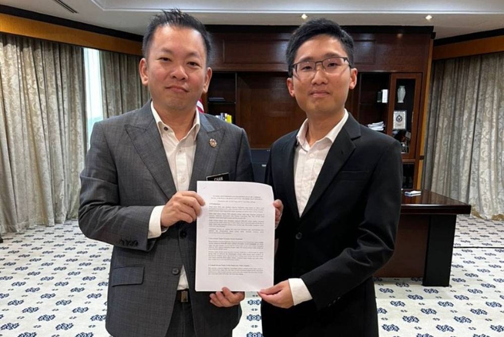 Foong Hin (kiri) menerima memorandum bagi menjelaskan kemelut pertanian di Cameron Highlands daripada Chi Yang di Putrajaya.