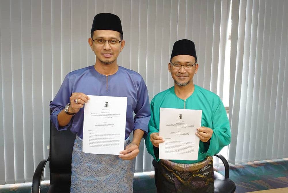 Mohd Fared (kiri) dan Baharin menunjukkan fatwa yang memberikan garis panduan kepada umat Islam untuk menghadiri upacara perayaan masyarakat bukan Islam selepas sidang akhbar di Pusat Islam Iskandar, Johor Bahru pada Khamis.