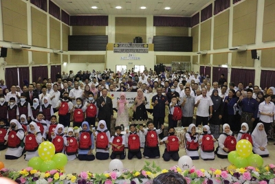 Fadhlina (berdiri, sembilan dari kanan) bergambar bersama pelajar yang menerima Pek Kembali ke Sekolah daripada RMHC Malaysia YDN dalam Majlis Pelancaran dan Penyerahan Sumbangan Pek Kembali Ke Sekolah, di SK Madrasah Datuk Hj. Abdul Kadir Hasan, Kuching.