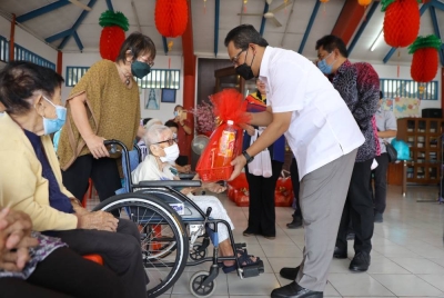 Nor Fuad (kanan) menyampaikan sumbangan wang tunai dan hamper kepada setiap penghuni dengan harapan mereka tidak merasa terpinggir