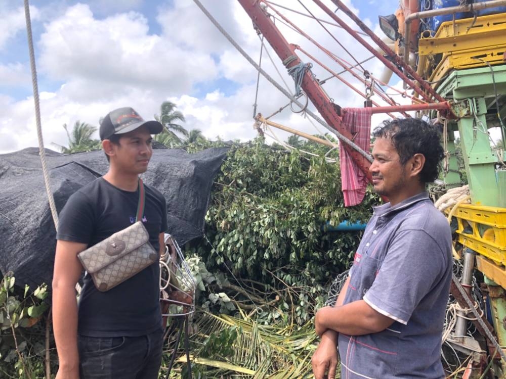 Mayaki (kanan) menceritakan kejadian dialaminya ketika bot karam kepada Jarhan pada Sabtu. 