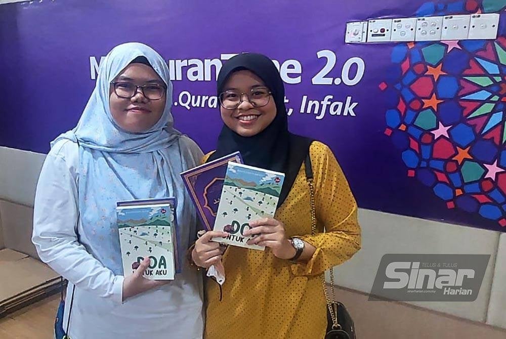 Aliah (Kanan) bersama rakannya Nur Afiqah Husni (kiri) ketika ditemui semasa Jualan Gudang Karangkraf 2023 di Kompleks Karangkraf, Seksyen 15, Shah Alam.