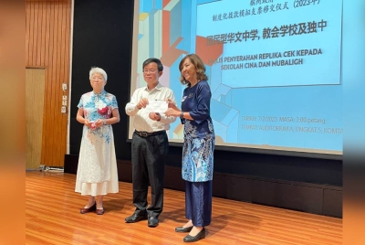 Kon Yeow menyerahkan cek kepada salah seorang penerima pada Majlis Penyerahan Replika Cek Kepada Sekolah Menengah Jenis Kebangsaan, Sekolah Mubaligh dan Sekolah Menengah Persendirian Cina 2023 di Komtar pada Selasa.