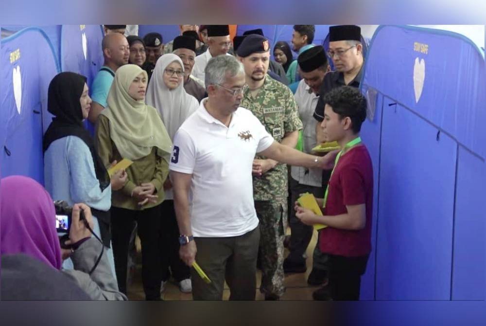 Al-Sultan Abdullah berkenaan menyantuni mangsa banjir di PPS Sekolah Agama Rakyat, Kelas Al-Quran dan Fardu Ain, Ubadiah Al-Jariah, Taman Guru pada Rabu.