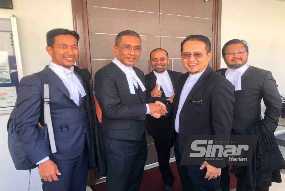 Takiyuddin (dua dari kiri) dan Ahmad Hanir (dua dari kanan) bersalaman selepas selesai prosiding pada Rabu.