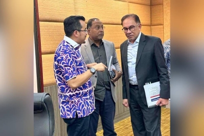 Asyraf (kiri) bersama Zambry (kanan) dan Anwar (tengah).